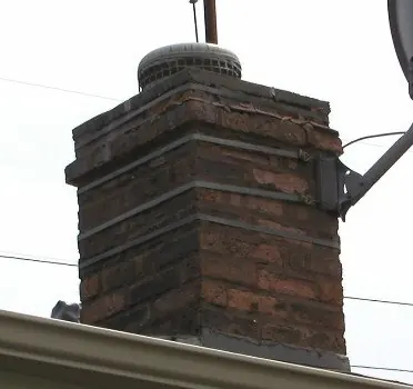 Rebuilt brick chimney with a freshly poured concrete crown